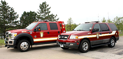 A red truck and a red SUV with fire department markings