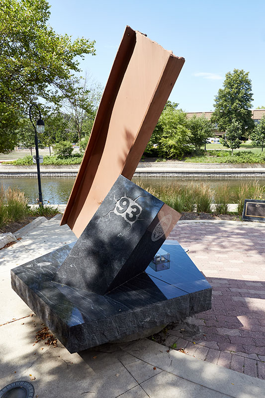 The Shanower Memorial is seen along the DuPage River. It features a gray sculpture with 100 pounds of rubble from the damaged Pentagon, as well as the number 93 for victims of the Pennsylvania airline crash.