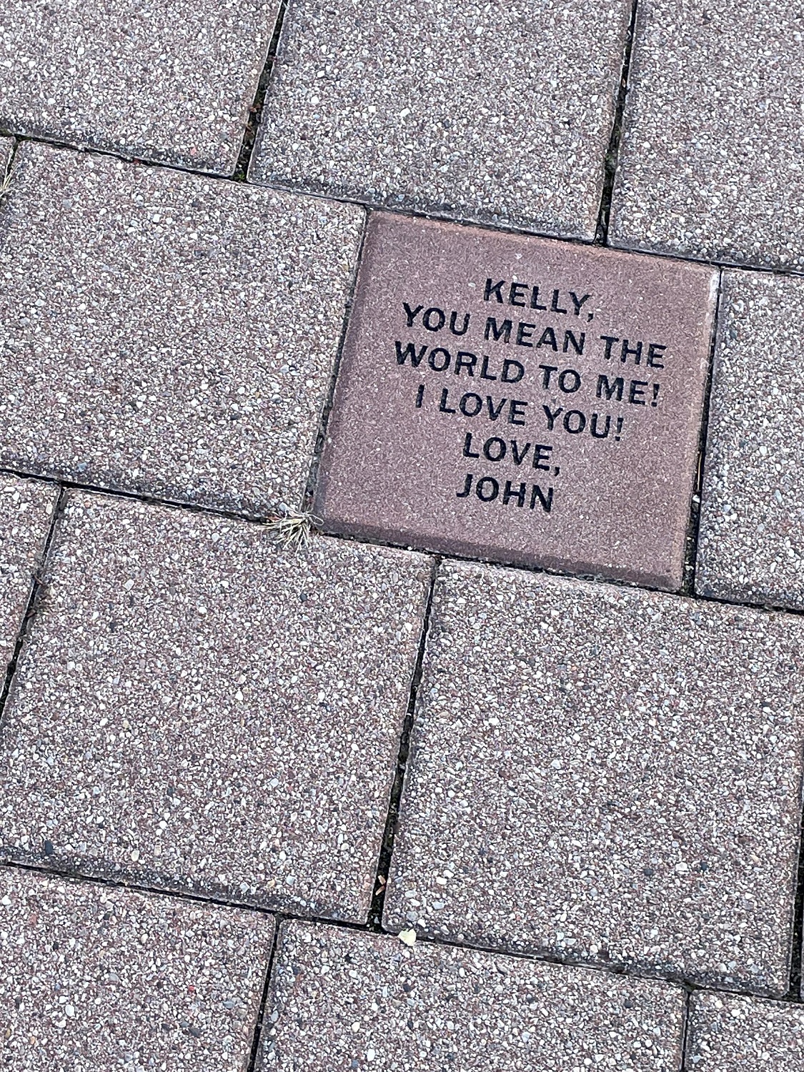 Sample of an 8-inch by 8-inch commemorative brick. Text says, "Kelly you mean the world to me. I love you! John"