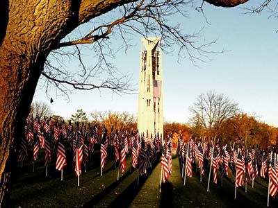 Millennium Carillon towers over a field decorated with small American flags.