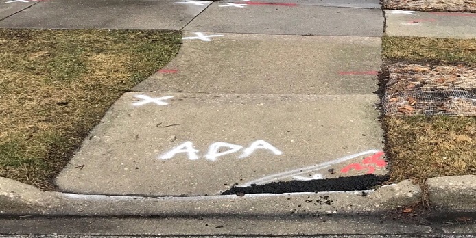 sidewalk sections spray-painted to indicate the need for ADA improvements