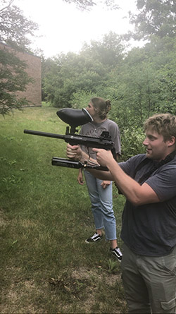 An intern uses a paintball gun in a training scenario
